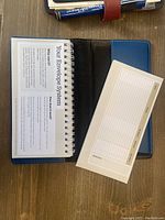 Close-up of open budget wallet showing 'Your Envelope System' guide page and an expense tracker card with columns for date, amount, spending category.