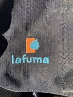 Close-up of the Lafuma logo embroidered on black fabric of the backpack.