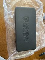 Black rectangular device bearing BrickHouse Security logo on the cover, wrapped in clear plastic.