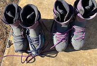 Top view of two pairs of used mountaineering boots showing wear and purple laces.