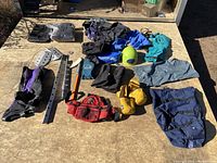 Wide view of all assorted mountaineering gear laid out on a flat surface under sunlight.