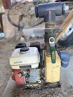 Left side view showing the water pump housing, inlet and outlet, and fuel tank on top of the engine.