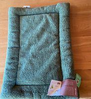 Full view of green West Paw pet bed with tags.