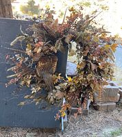 Full view of the autumn wreath prominently displaying leaves, berries, and mounted pheasant.
