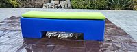 Front view of bench with cushion showing full length profile on outdoor surface