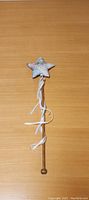 Full view of the fairy wand with wooden handle placed on a wooden surface