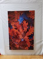 Front view of the acrylic-framed photographic print showing vibrant red leaves against a blue background.