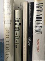 Photo showing five of the seven books lined up vertically, titles readable: 'Gold Boxes of Europe,' 'The Book of Old Silver,' 'Silver,' 'Art Nouveau,' and a partially visible book.