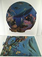Two prints displayed: a circular underwater scene with whale and sea creatures, and a rectangular underwater reef scene with whales and fish.