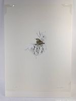 Full view of the limited edition print showing a bird on snowy branches with artist signature and Roman numeral number visible.