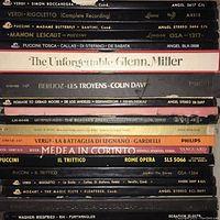 Close up photo of a stack of various classical music vinyl LP records showing album spine titles, including Verdi, Puccini, Berlioz, Glenn Miller.