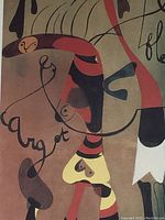 Close-up photo of colorful abstract Joan Miró artwork with organic shapes and flowing lines predominantly in red, black and yellow tones.