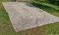 Full view of rug laid on grass showing overall pattern and shape