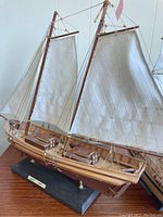 Front angle showing the Swift model ship with cloth sails, wooden structure, mounted on a black base.
