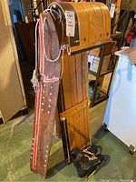Full view of the toboggan, Snurfer snowboard, and ice skates grouped together showing overall condition and size.
