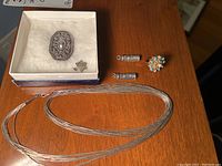 Entire lot arranged on wood surface showing necklace, pendants, and ring