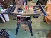 Front view showing the table saw work surface, motor housing with Sears Craftsman branding, and the metal stand.
