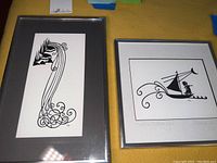 Two framed pieces of Marcia Guthrie cut paper wall art displaying abstract and nautical designs.