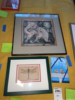 Three wall art pieces showing two framed prints and one unframed painting grouped together on yellow fabric.