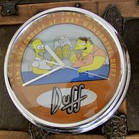 Front view of Homer Simpson Duff wall clock showing the clock face with Homer and Barney holding beer mugs and Duff logo.