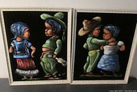 Two framed black velvet paintings showing Mexican boy and girl in traditional dress, one facing each other and the other embracing.