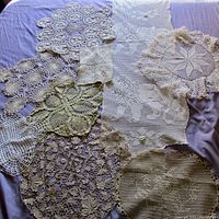 Top-down photo showing all seven doilies arranged on a purple cloth, highlighting the different shapes, patterns, colors and textures of each item.