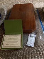 Closed wooden display case with partially visible certificate booklet.