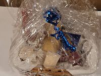 Overview of Christmas gift basket with all items visible in cellophane wrap and blue ribbon