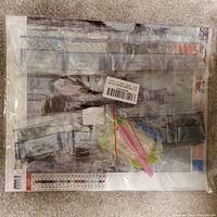 Close up of another diamond painting kit with beads and tools visible in plastic packaging showing color-coded beads and chart.