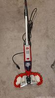 Full length view of the Upright Dirt Devil vacuum with mop attachment showing plugged-in power cord.