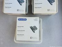Three boxes of Amerock decorative hinges with oil rubbed bronze finish, each box containing 10 hinges.