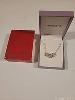 Michael Hill branded purple box with necklace and outer red box visible on side.