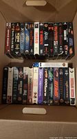 Box of VHS movies neatly lined up showing spine titles with various movie names, including Donnie Brasco, Fargo, The Firm, Black Beauty, and others.
