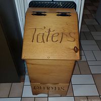 Top view shows hinged lid labeled 'Taters' with black metal hinges and natural wood finish.