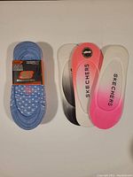 8 pairs of Skechers superlow shoe liners in multiple colors, some stacked and some laid out flat showing the branding and color gradients.