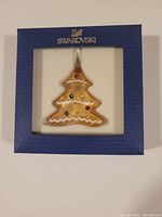 Ornament displayed centered in original blue box with Swarovski logo above