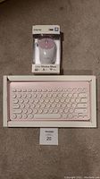 Front view of iHome retro pink wireless keyboard and wireless mouse in packaging.