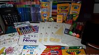 Full view of assorted art supplies including Crayola markers, crayons, pencils, tracing paper, Sharpie markers, coloring book, chalk, and paper pads