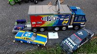 Photo of DuPont racing truck trailer, Dale Earnhardt car #2, UT Mercedes race car and a small purple toy car