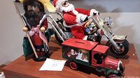 Photo showing all three items: nutcracker figurine, motorcycle Santa, and truck bank with Santa image