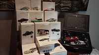 Photo showing the 13 Hallmark Keepsake ornaments in original boxes with vehicle images and names visible.