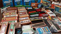 Overall view of boxed Tyco freight cars, loose cars, track sections and scenery boxes
