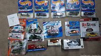 Top photo overview of all 14 die cast cars in various packages and boxes, showing scale and condition
