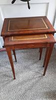Pair of vintage nesting tables stacked with decorative gold inlay and tapered legs.
