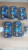 Five unopened Schlage bed and bath locking doorknobs in individual blister packaging, placed on cardboard surface.