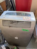 Full front and top view of the NOMA free standing air conditioner showing size label and Apple logo sticker.