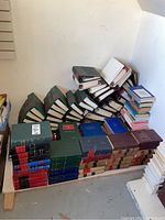 Full view of the legal book collection stacked along the wall, includes volumes with red, green, black bindings and various sizes.