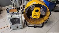 Dewalt drum fan and Airworks floor heater visible side by side on tile floor showing power cords and general condition.
