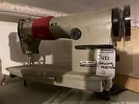 Front and side view of Juki sewing machine on a metal sewing bed showing model number and wired part.