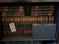 Three shelves of green cloth law report volumes with red and black spine labels